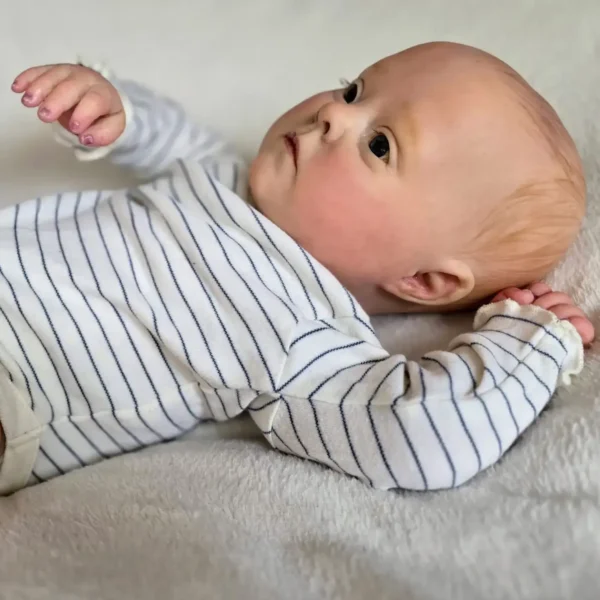Side view of Realborn Patience reborn baby laying on a blanket