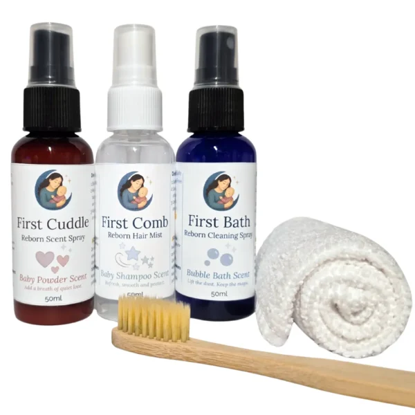 Three Moon & Milk Dolls reborn care sprays with a bamboo brush and white lint-free cloth arranged on a clean background.