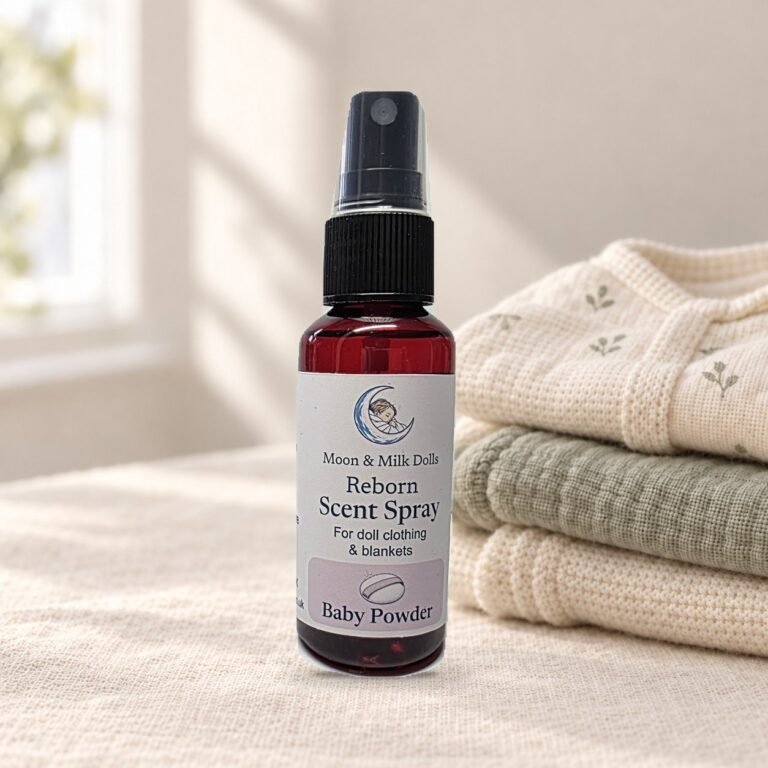 Baby powder reborn scent spray, 50 ml, on cream linen beside folded fabric.